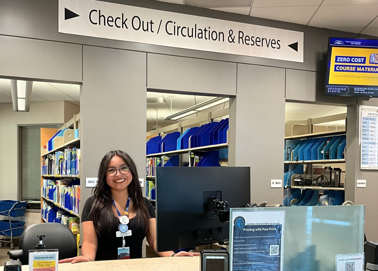 An employee sitting down at at the Circulation and Reserves Desk
